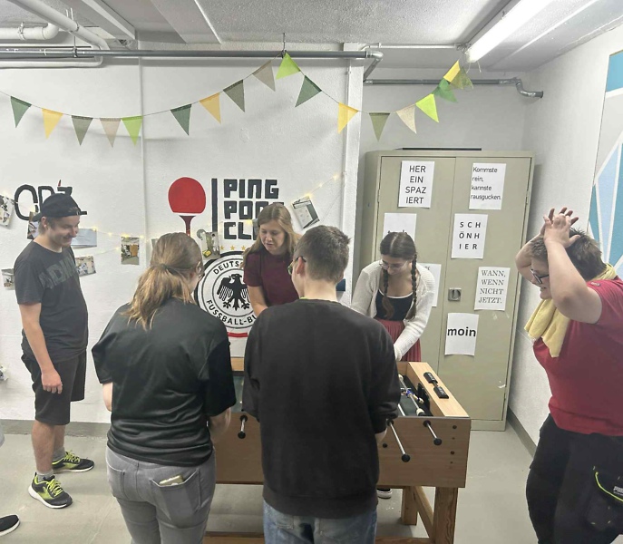 Azubis spielen Tischfußball im Freizeitraum