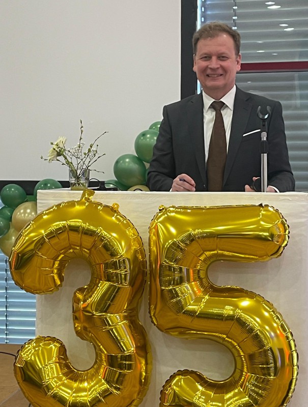 Herr Majewski hinter einem Tresen  zum 35-jährigen Jubiläum